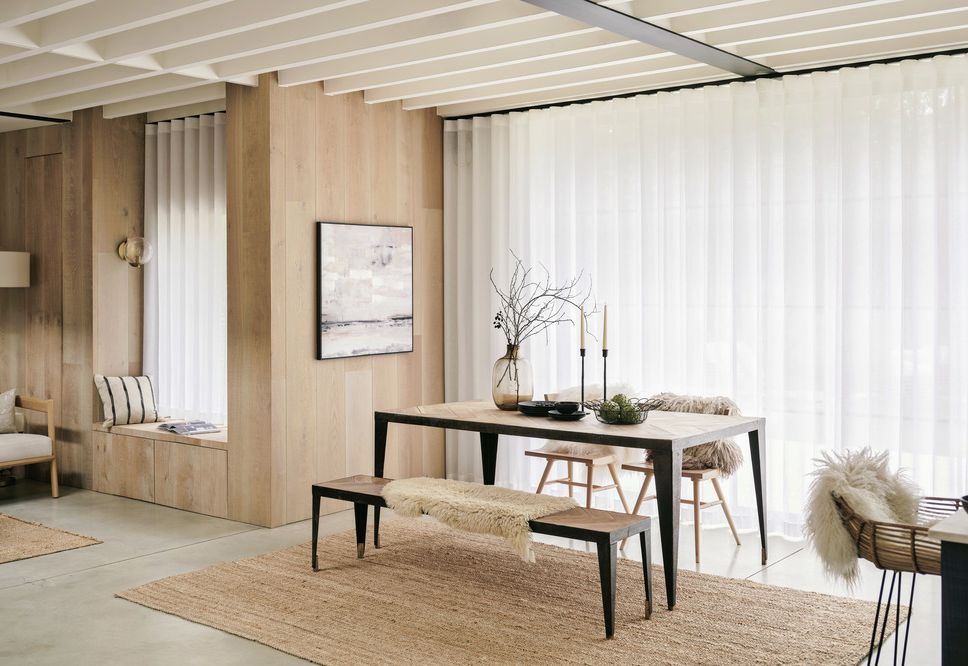 Open-plan dining with full-width sheer curtains and oak-clad reading nook
