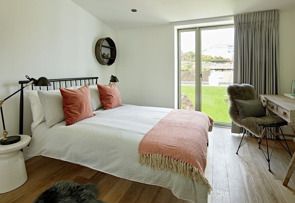 Bedroom with pencil pleat curtains and garden outlook