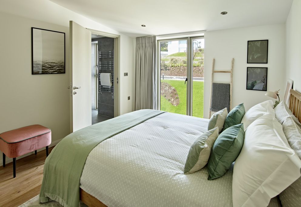 Guest bedroom with curtains and en-suite, garden view