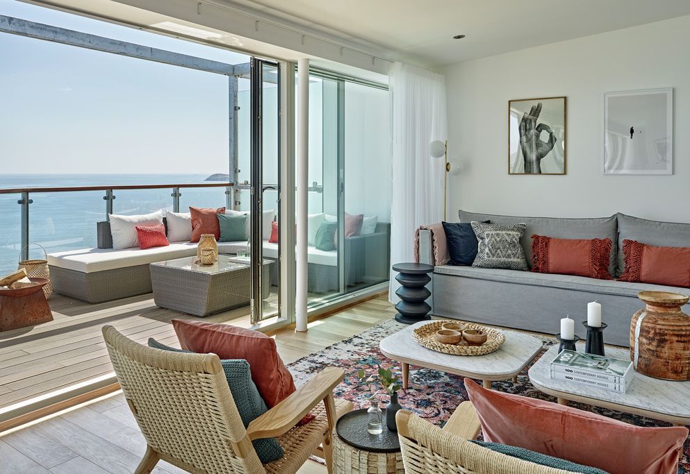 Open-plan living area with balcony and panoramic coastal views