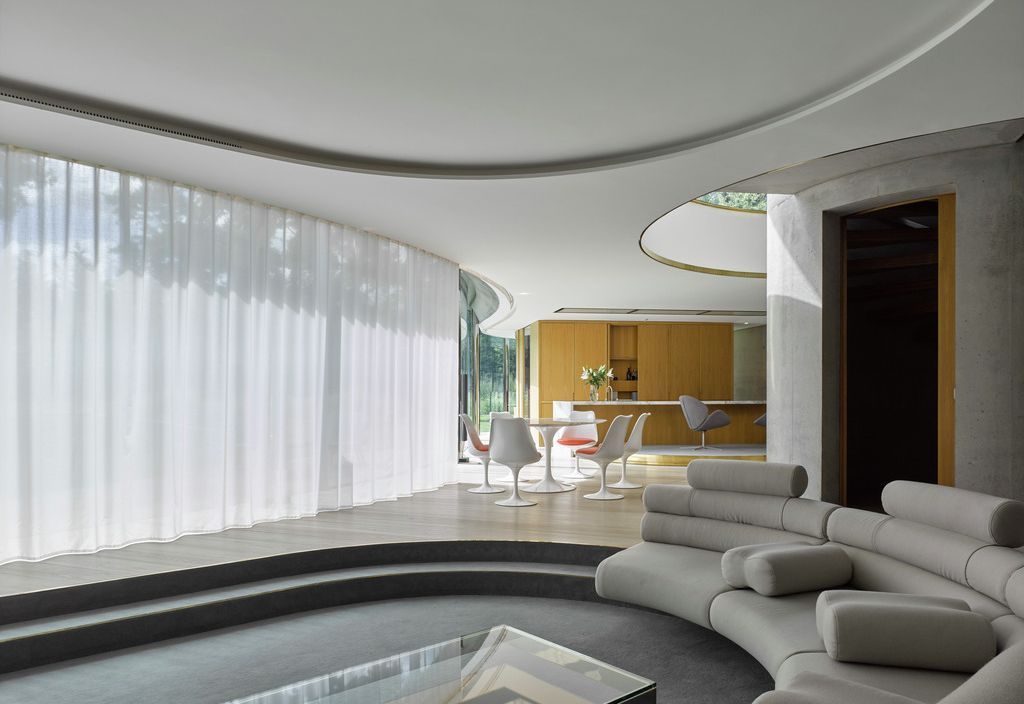 Open-plan living space with sheer Wave curtains and curved sofa