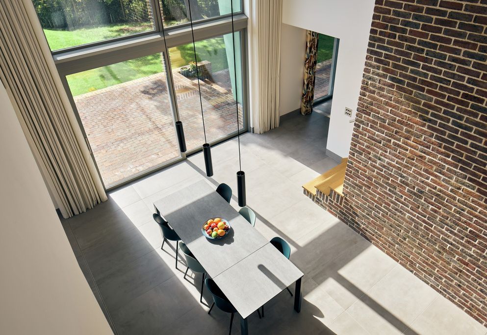 Double-height dining area with floor-to-ceiling glass and Wave curtains