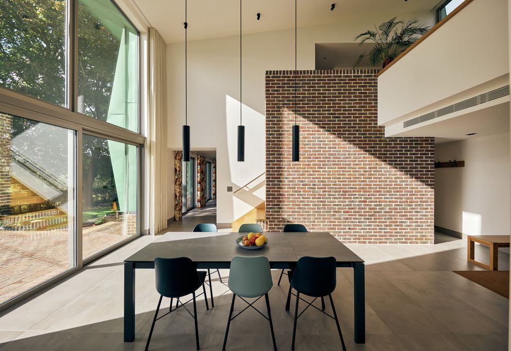 Open-plan dining and living space with exposed brick and pendant lights