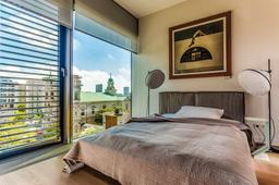 Silent Gliss 4960 roller blind in a modern bedroom with floor-to-ceiling windows